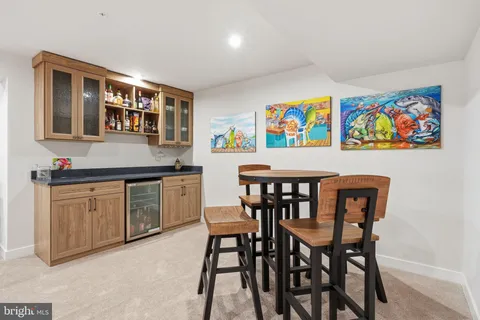 a kitchen with stainless steel appliances granite countertop a dining table chairs stove and sink