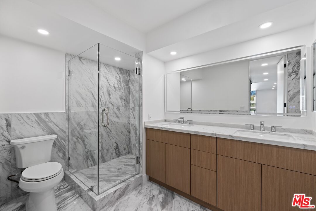 1100 Alta Loma Road, Unit 902 West Hollywood, CA 90069 - Photo 8 of 17 a bathroom with a double vanity sink toilet and a shower