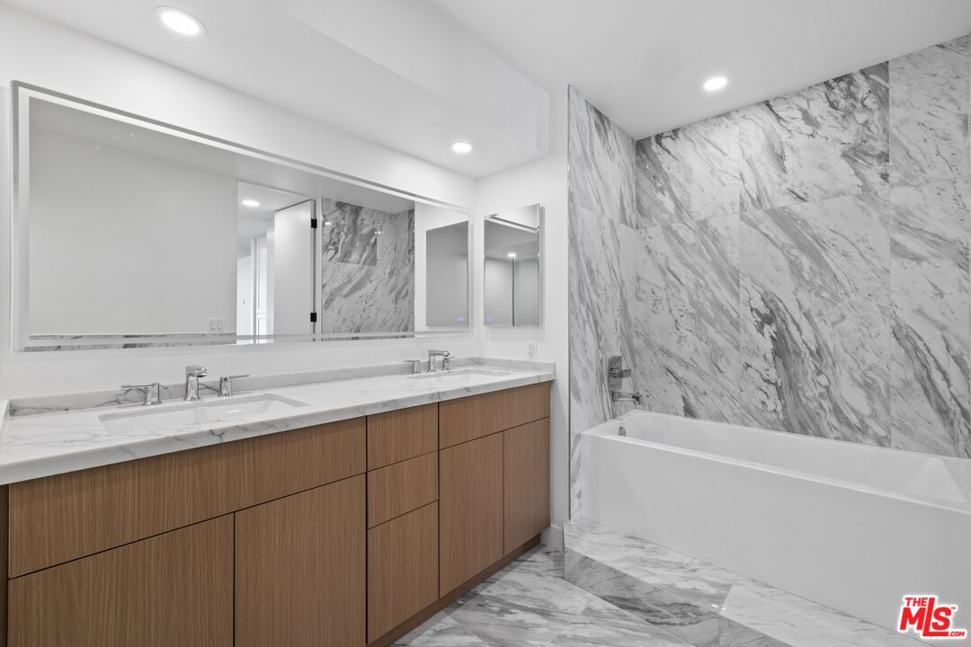 1100 Alta Loma Road, Unit 902 West Hollywood, CA 90069 - Photo 10 of 17 a bathroom with a granite countertop sink mirror and a bath tub