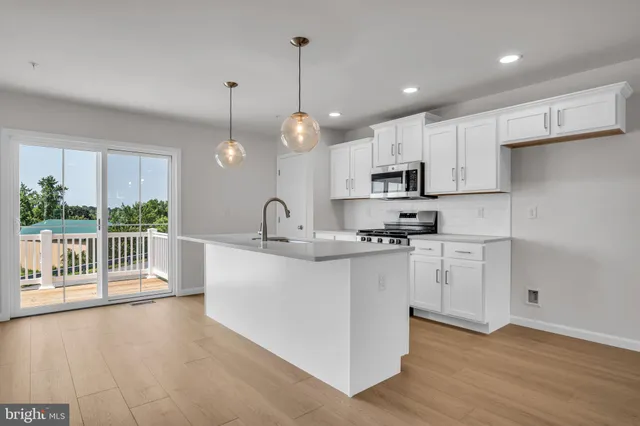 a kitchen with stainless steel appliances granite countertop a sink a stove a refrigerator and cabinets