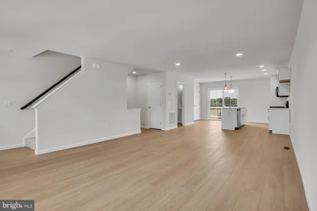 a view of kitchen with refrigerator and wooden floor