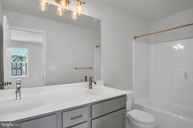 a bathroom with a sink toilet a mirror and shower