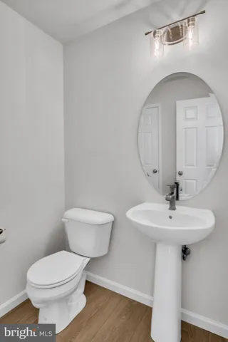 a bathroom with a toilet a sink and mirror