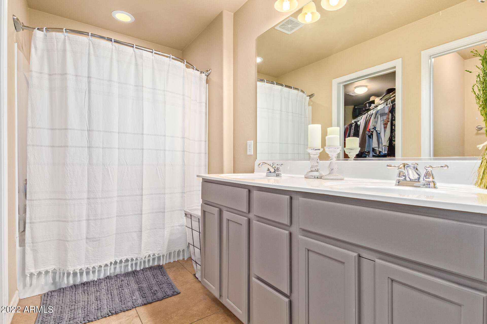 20748 West White Rock Road Buckeye, AZ 85396 - Photo 18 of 34 a bathroom with a double vanity sink a mirror and a shower