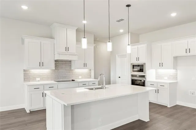 a kitchen with white cabinets and stainless steel appliances
