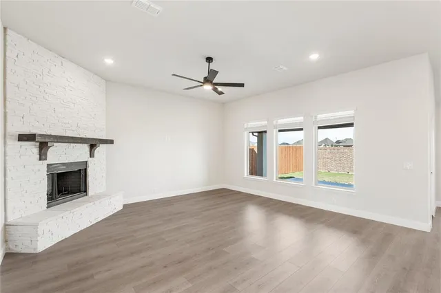 an empty room with windows and fireplace