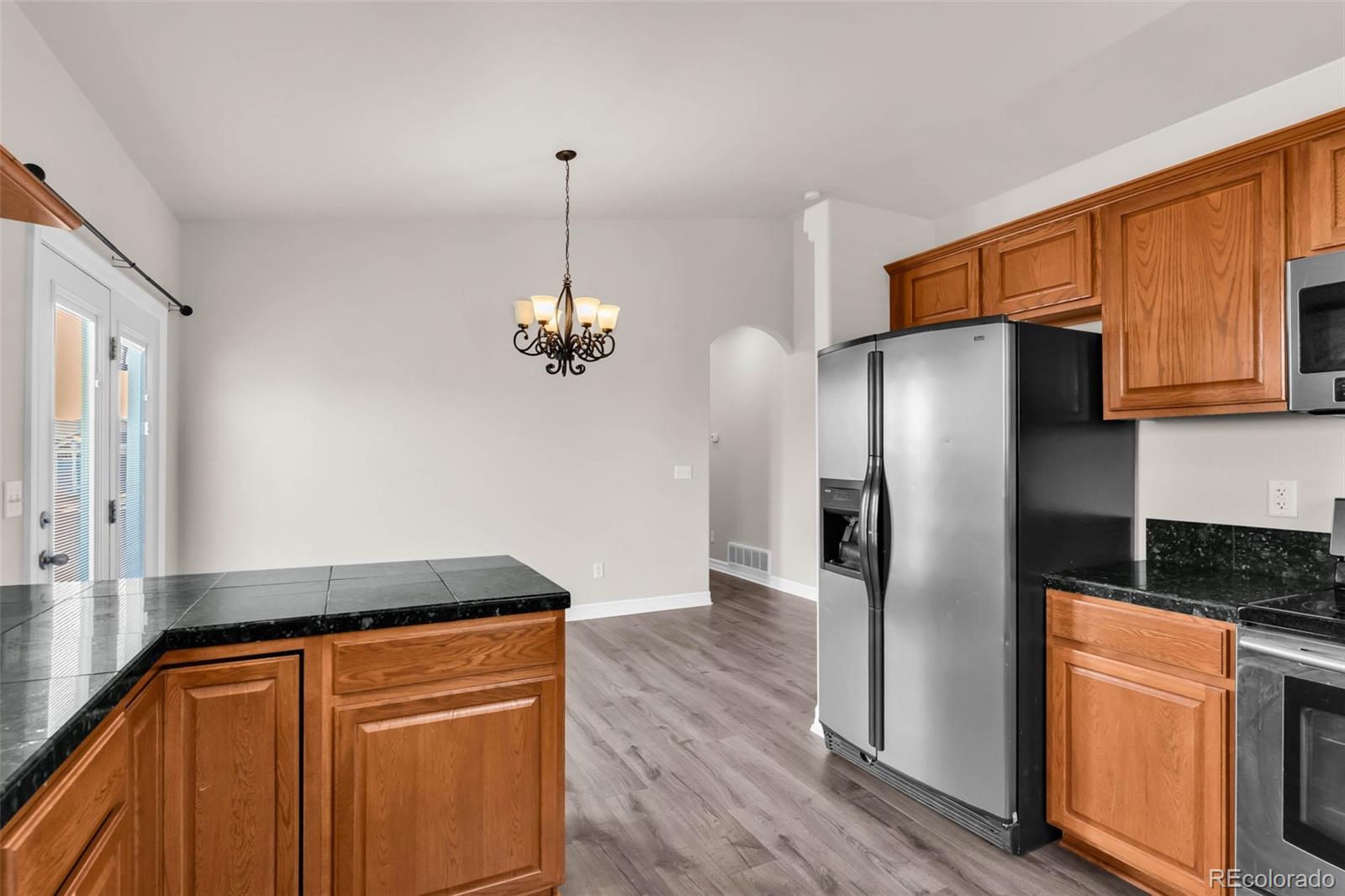 249 High Meadows Drive Florence, CO 81226 - Photo 13 of 47 a kitchen with stainless steel appliances granite countertop a refrigerator a stove and a sink with wooden floor