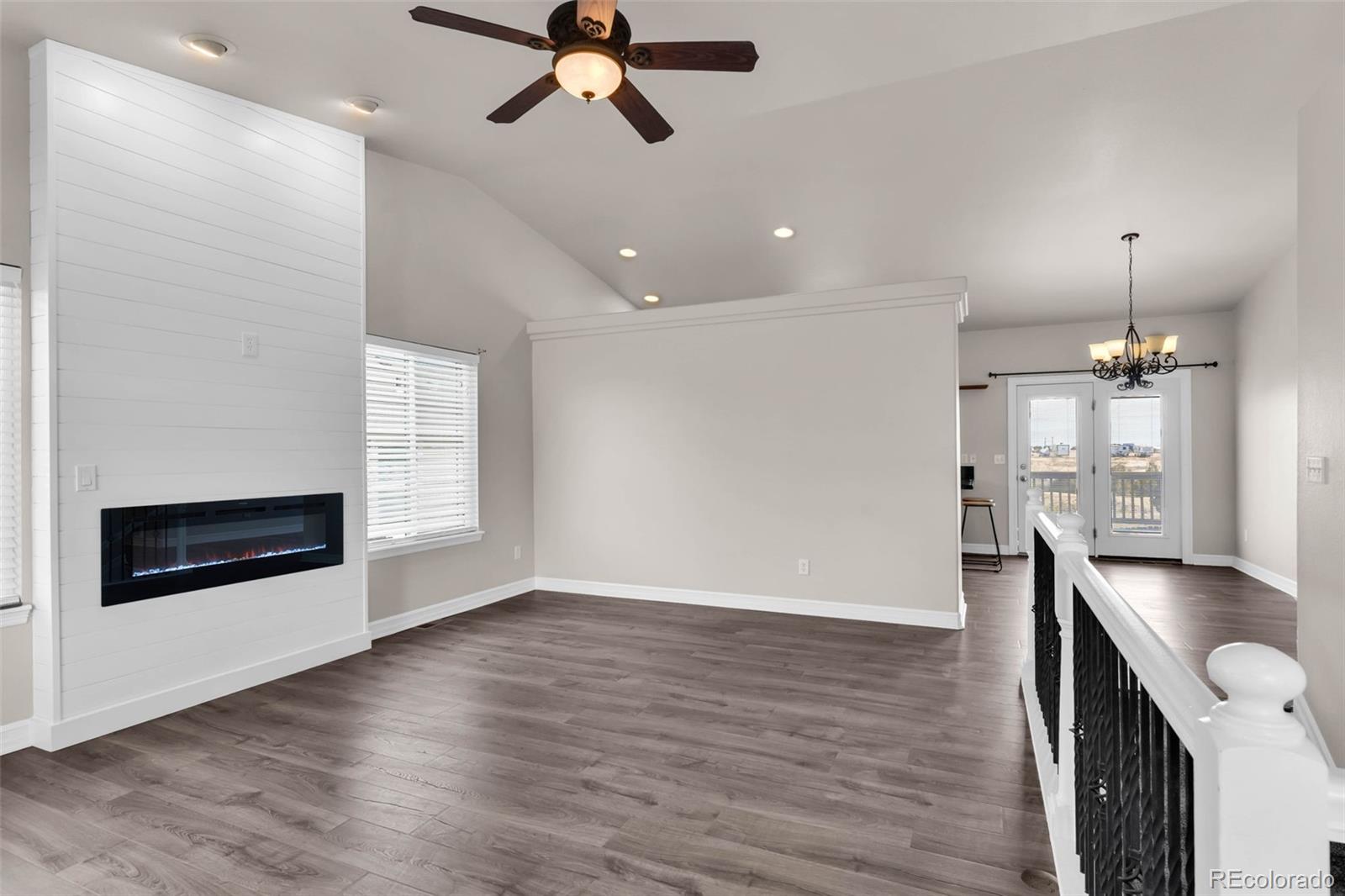 249 High Meadows Drive Florence, CO 81226 - Photo 4 of 47 an empty room with wooden floor a ceiling fan and windows