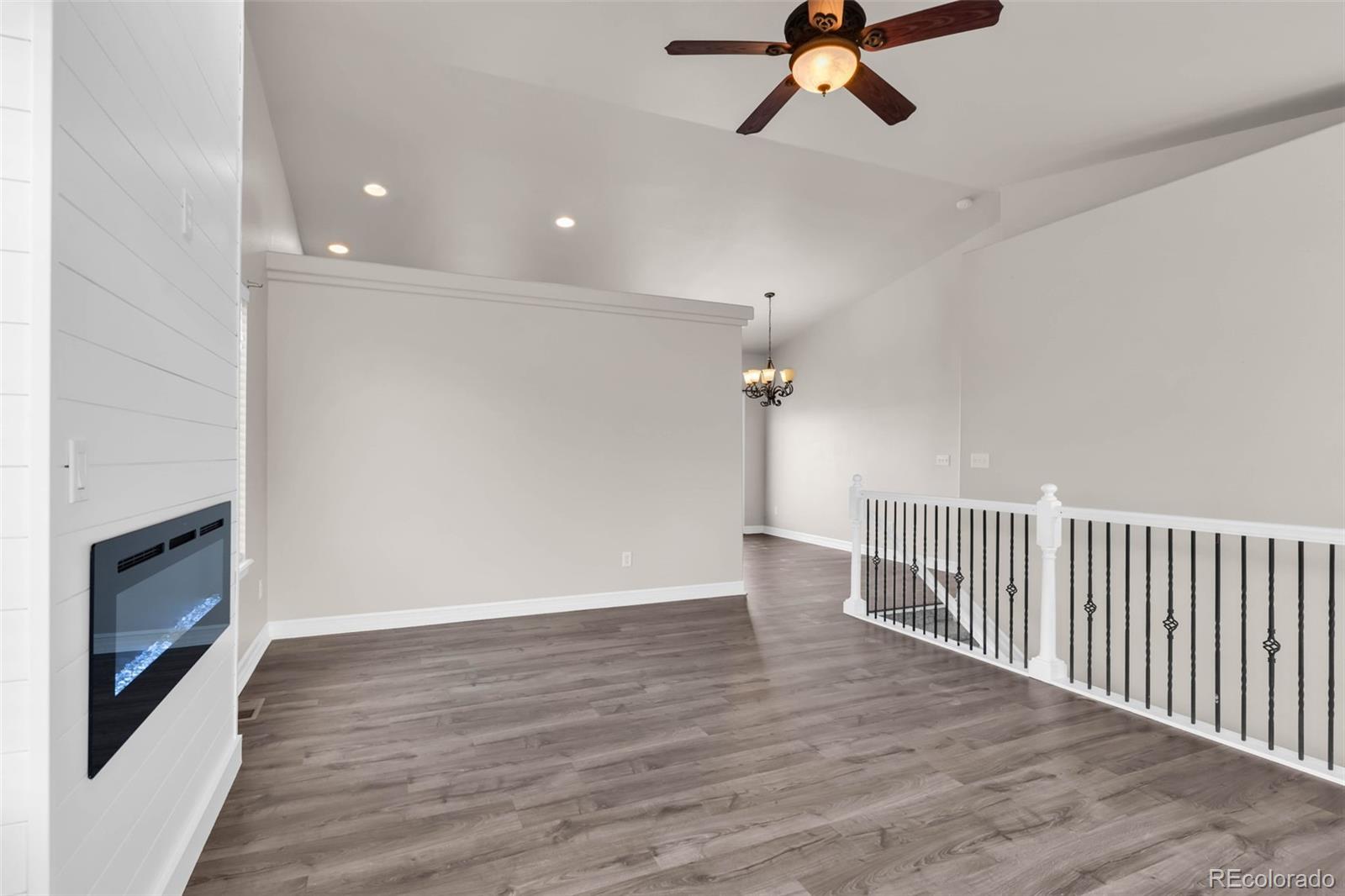 249 High Meadows Drive Florence, CO 81226 - Photo 5 of 47 a view of a livingroom with a fireplace wooden floor and chandelier fan