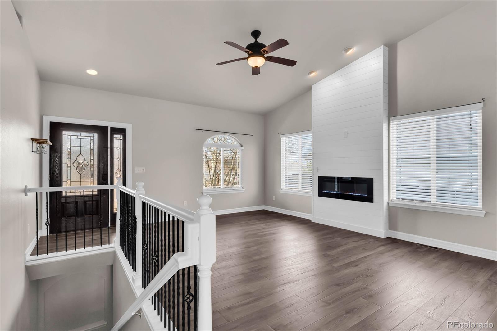 249 High Meadows Drive Florence, CO 81226 - Photo 7 of 47 an empty room with wooden floor a ceiling fan and windows