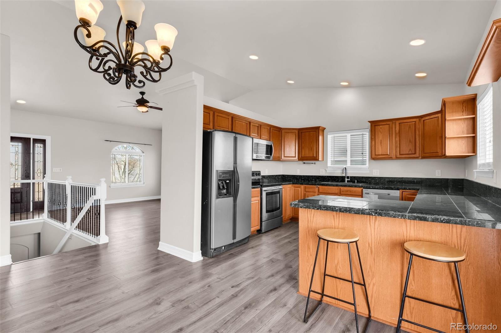 249 High Meadows Drive Florence, CO 81226 - Photo 9 of 47 a kitchen with stainless steel appliances granite countertop a refrigerator a stove top oven and a dining table with wooden floor