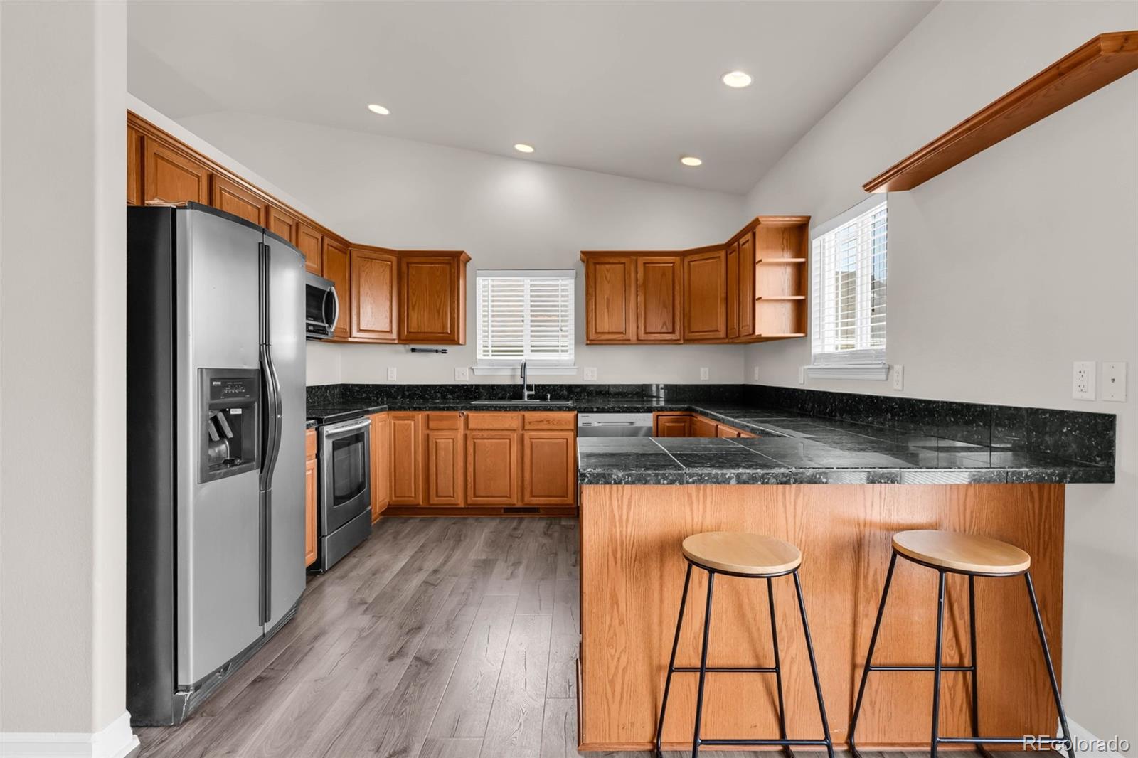 249 High Meadows Drive Florence, CO 81226 - Photo 10 of 47 a kitchen with stainless steel appliances granite countertop wooden cabinets a refrigerator a sink a stove and a wooden floors