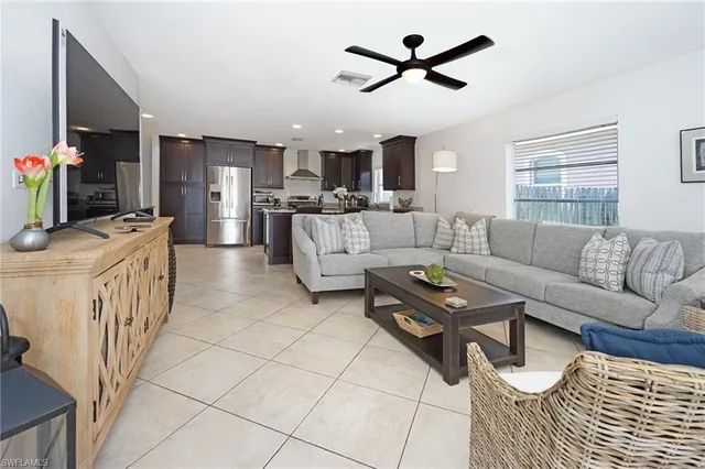 a living room with furniture a ceiling fan and a rug