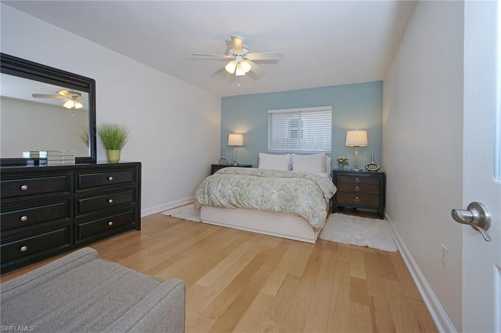 768 96th Avenue North Naples, FL 34108 - Photo 24 of 34 a bedroom with a bed and a chandelier