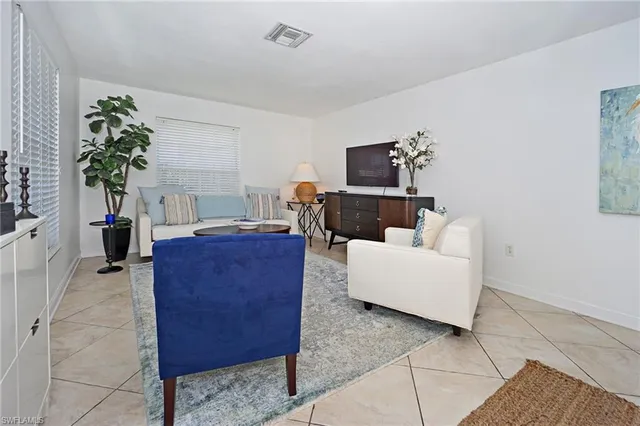 a living room with furniture a potted plant and a fireplace