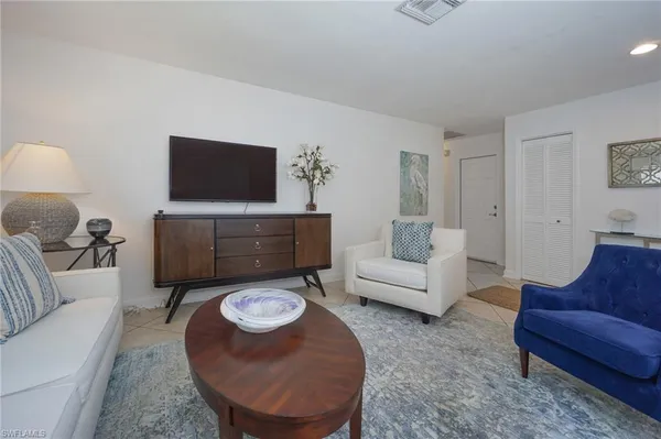 a living room with furniture a rug and a flat screen tv