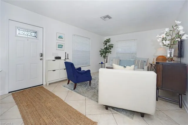a living room with furniture a chandelier and a dining table