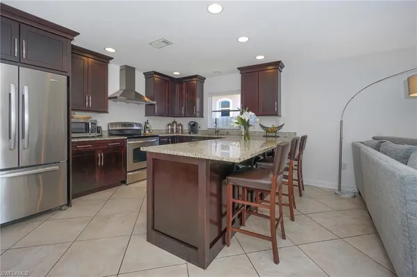 a kitchen with stainless steel appliances granite countertop a sink a stove a refrigerator and a refrigerator