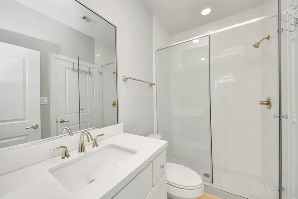 a bathroom with a granite countertop sink a toilet and a mirror