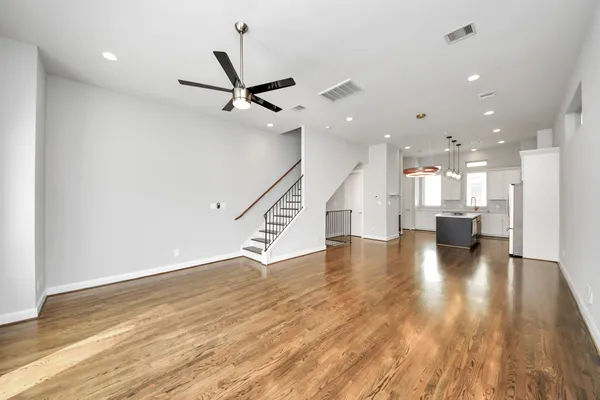an empty room with wooden floor and staircase