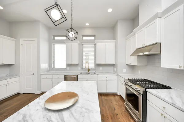 a large kitchen with granite countertop a sink cabinets and wooden floor