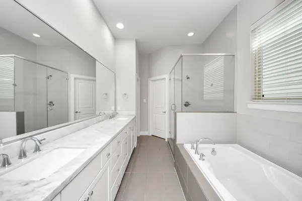 a spacious bathroom with a tub sink and mirror