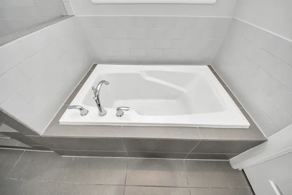 a bathroom with a granite countertop tub sink and mirror