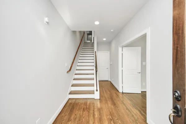a view of a big room with wooden floor and windows