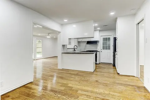 a large kitchen with a refrigerator and a stove top oven