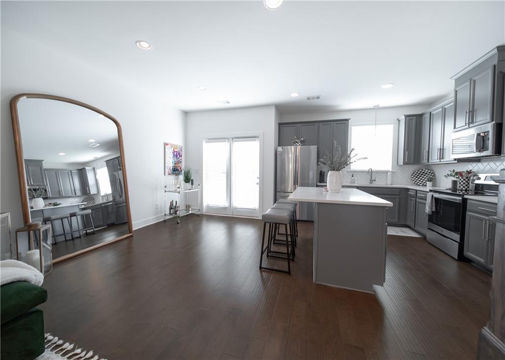 6350 Princeton Ridge Drive Lithonia, GA 30058 - Photo 18 of 45 a living room with couches and kitchen view with wooden floor