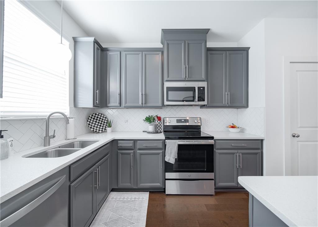 6350 Princeton Ridge Drive Lithonia, GA 30058 - Photo 20 of 45 a kitchen with stainless steel appliances granite countertop a sink stove and microwave