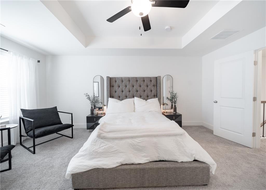 6350 Princeton Ridge Drive Lithonia, GA 30058 - Photo 26 of 45 a large bed sitting in a bedroom next to a cabinet with a potted plant on a dresser