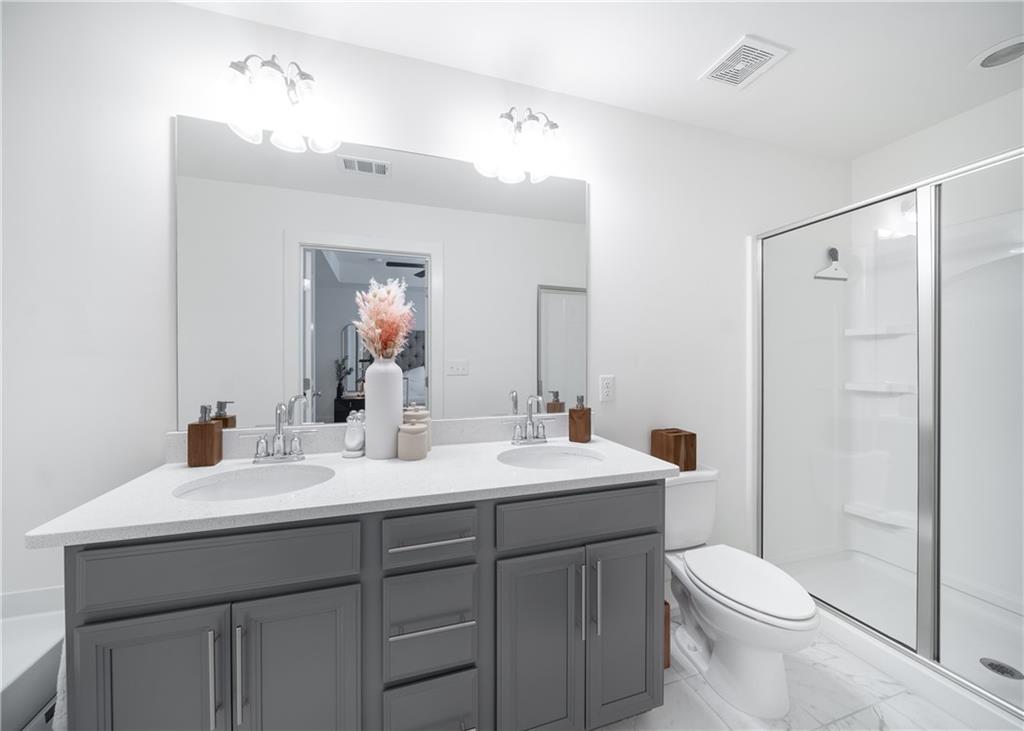 6350 Princeton Ridge Drive Lithonia, GA 30058 - Photo 32 of 45 a bathroom with a double vanity sink toilet mirror and shower