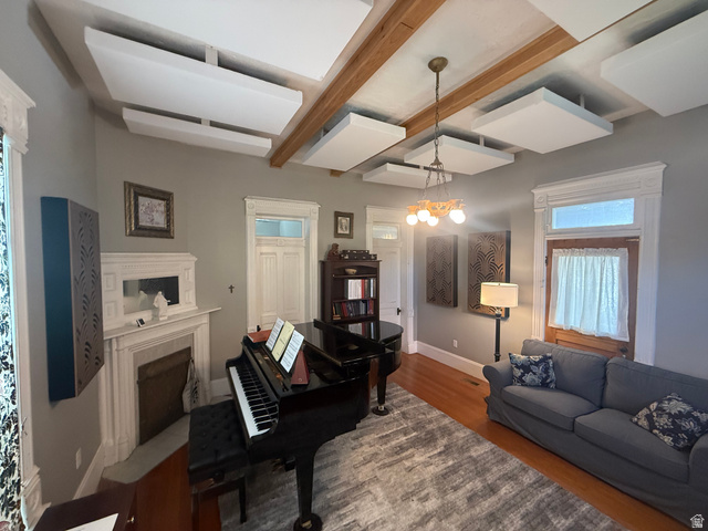 541 300 North Provo, UT 84606 - Photo 16 of 36 Living area featuring wood-finish flooring, a decorative fireplace with an ornate mantel, and a multi-bulb chandelier