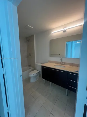 a white toilet sitting next to a bath tub and a shower