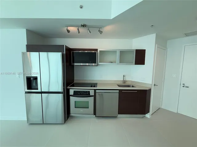 a kitchen with stainless steel appliances granite countertop a refrigerator and a sink
