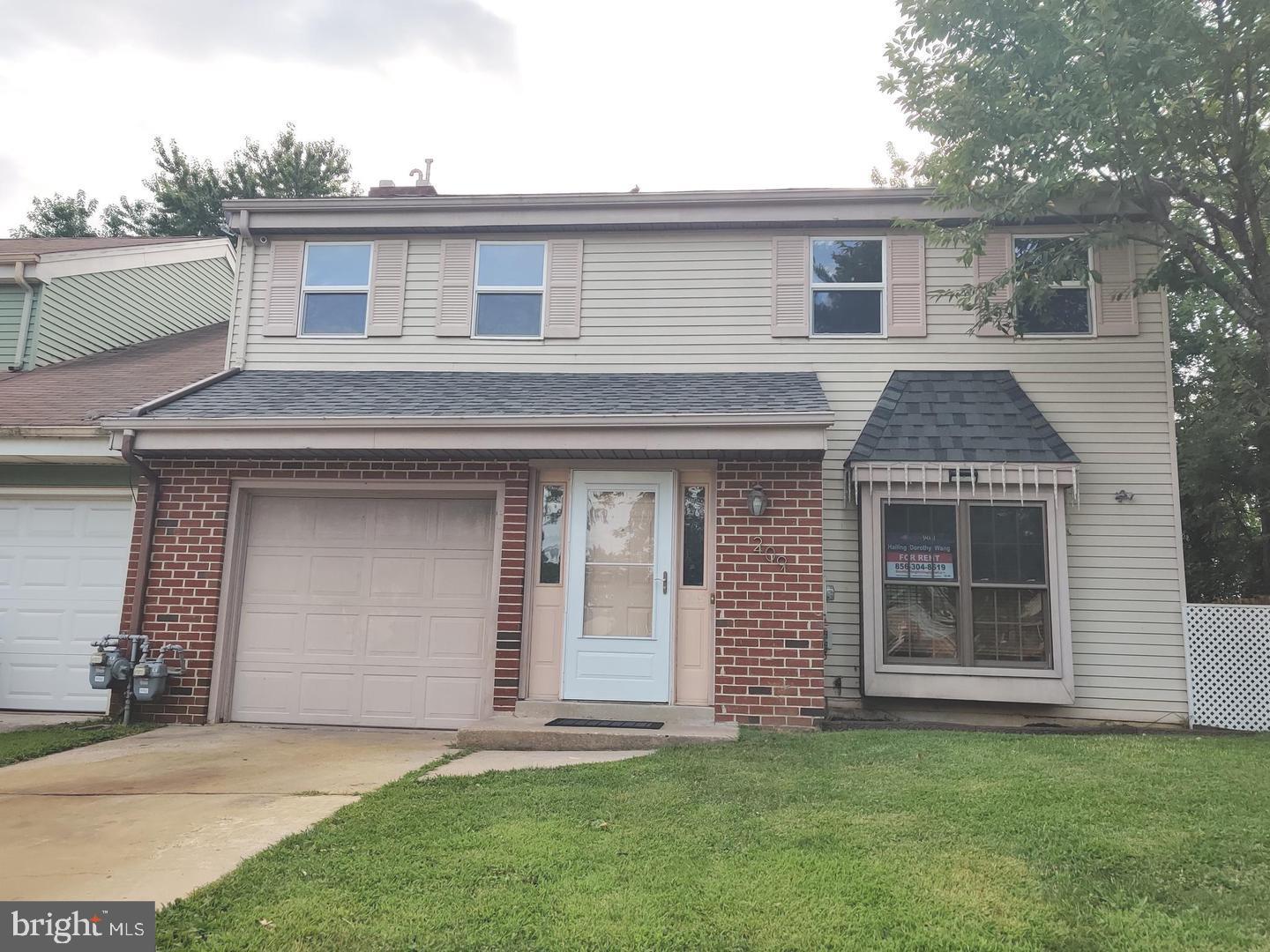a front view of a house with a garden and yard