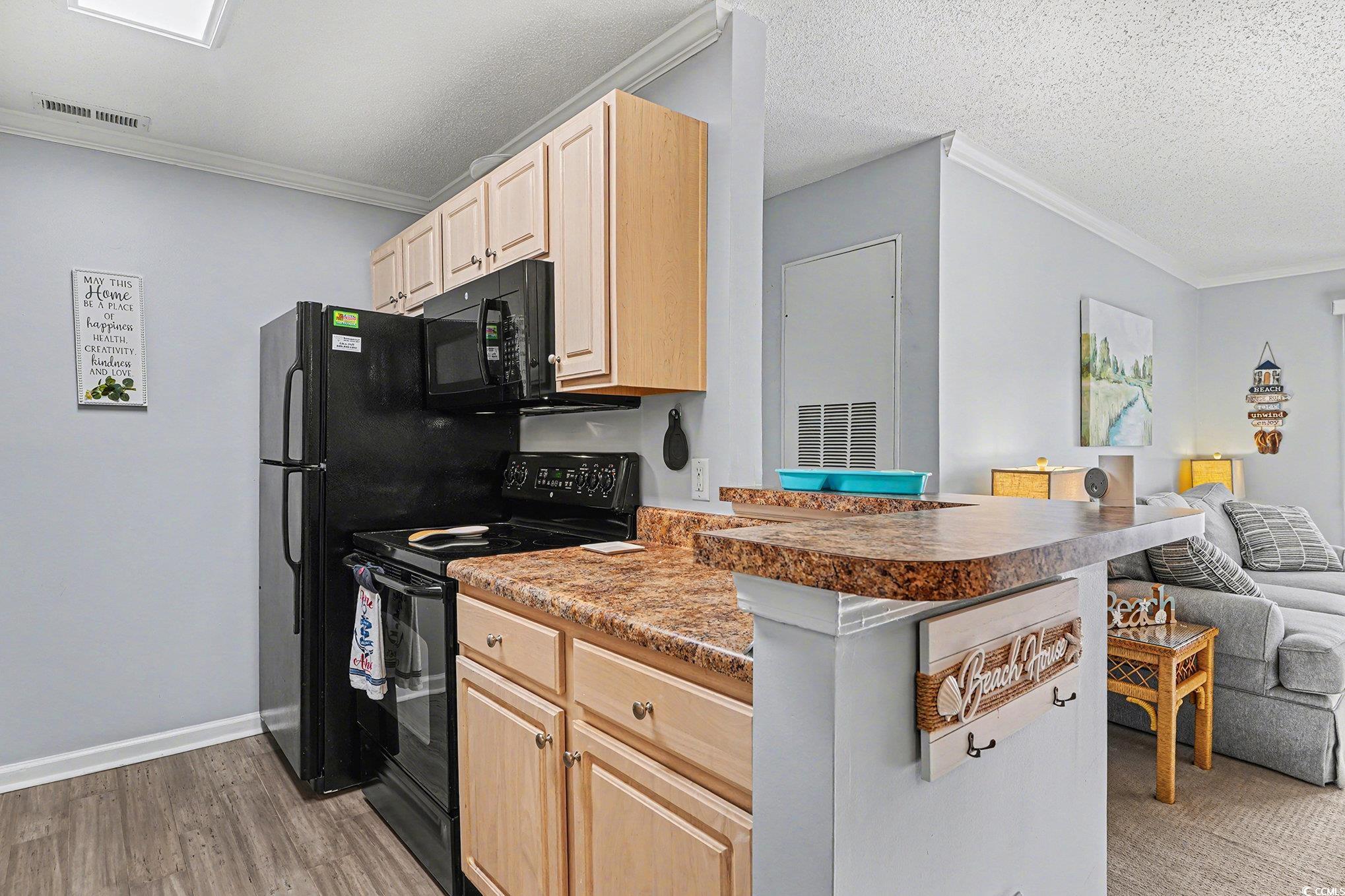 3756 Citation Way, Unit 926 Myrtle Beach, SC 29577 - Photo 35 of 35 Kitchen featuring open floor plan, light brown cabinetry, black electric range oven, crown molding, and dark countertops