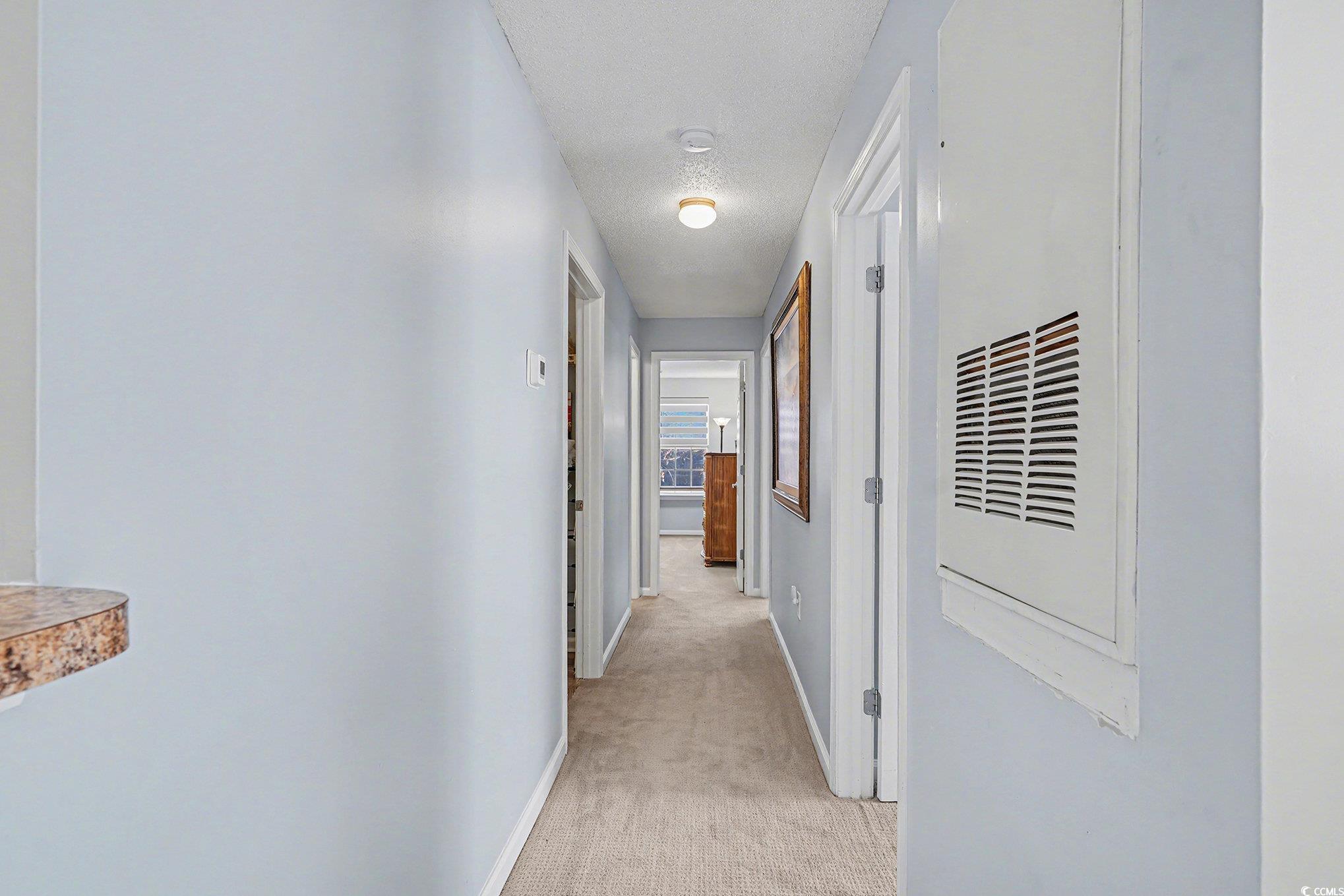 3756 Citation Way, Unit 926 Myrtle Beach, SC 29577 - Photo 11 of 35 Hall with light colored carpet, a heating unit, and a textured ceiling