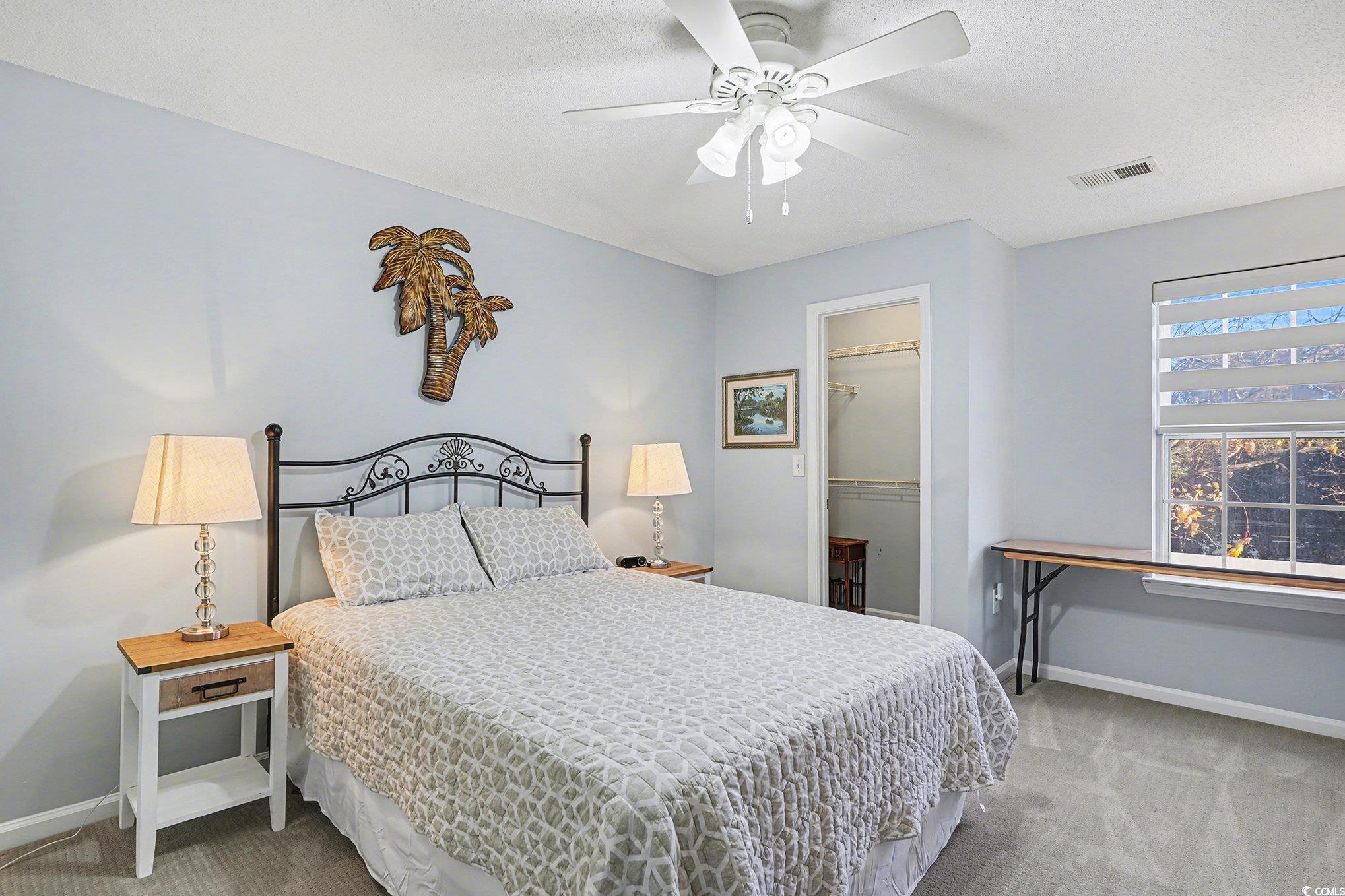 3756 Citation Way, Unit 926 Myrtle Beach, SC 29577 - Photo 17 of 35 Bedroom featuring a spacious closet, light carpet, a ceiling fan, and a textured ceiling