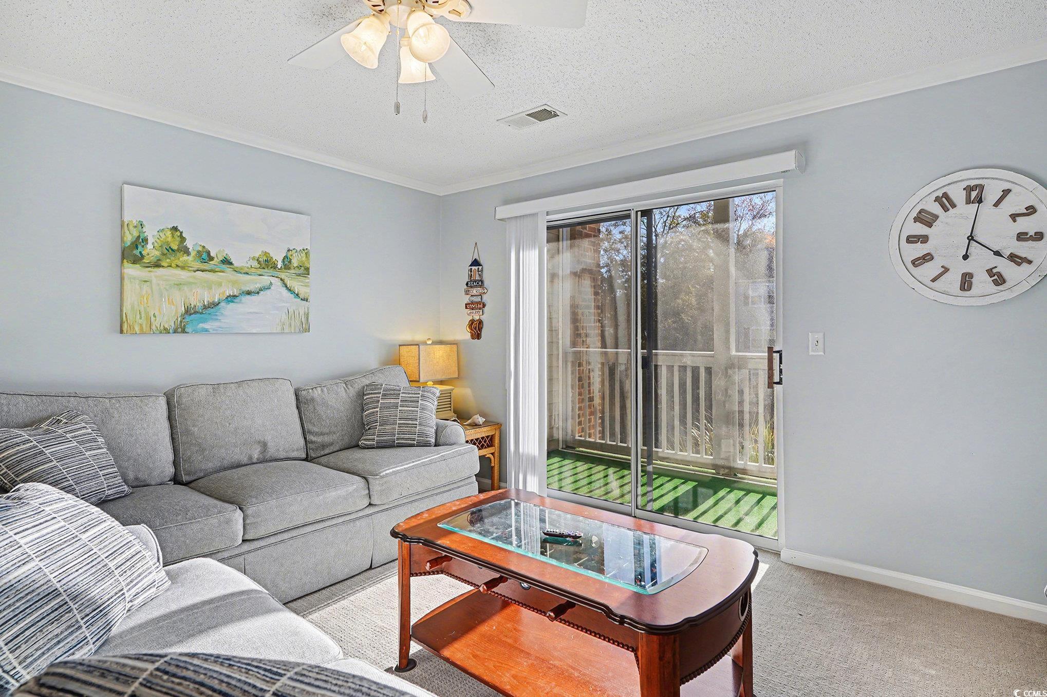 3756 Citation Way, Unit 926 Myrtle Beach, SC 29577 - Photo 5 of 35 Living room featuring a textured ceiling, a ceiling fan, carpet flooring, and crown molding