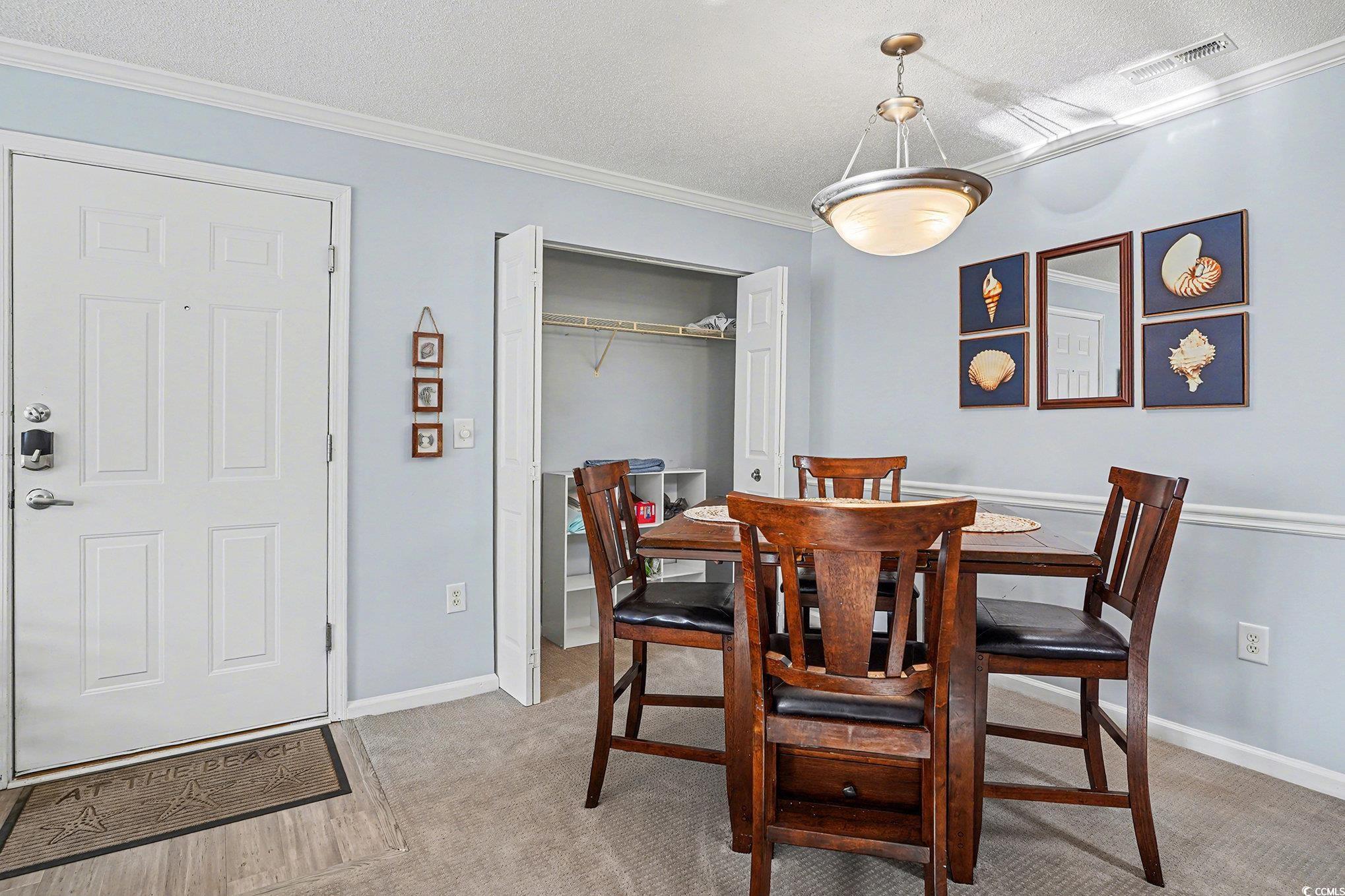 3756 Citation Way, Unit 926 Myrtle Beach, SC 29577 - Photo 9 of 35 Dining space featuring a textured ceiling, ornamental molding, and light colored carpet