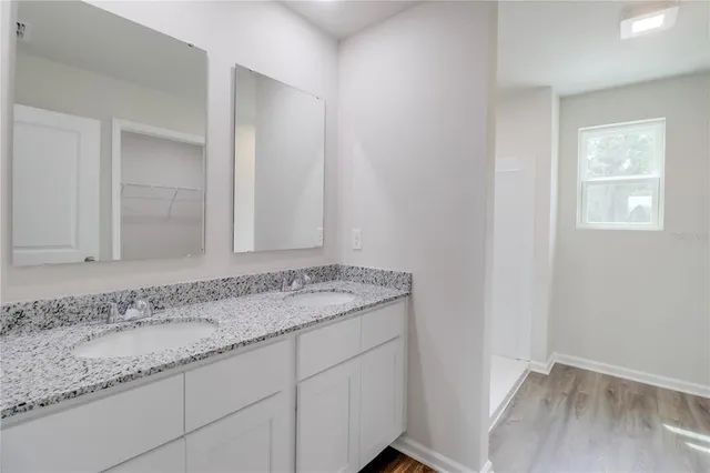 a bathroom with a granite countertop sink and a mirror