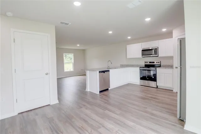 a view of kitchen with wooden floor and electronic appliances