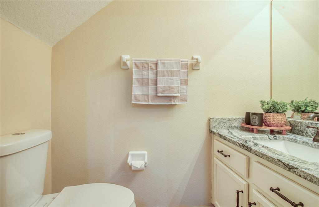 648 Spring Lake Circle Tarpon Springs, FL 34688 - Photo 13 of 30 a bathroom with a granite countertop toilet sink and mirror