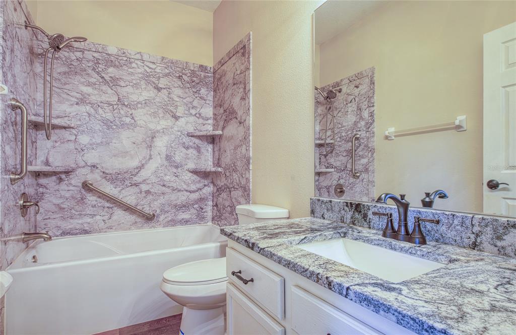 648 Spring Lake Circle Tarpon Springs, FL 34688 - Photo 21 of 30 a bathroom with a granite countertop sink toilet and bathtub