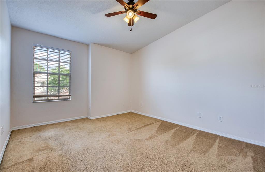 648 Spring Lake Circle Tarpon Springs, FL 34688 - Photo 22 of 30 an empty room with windows and ceiling fan