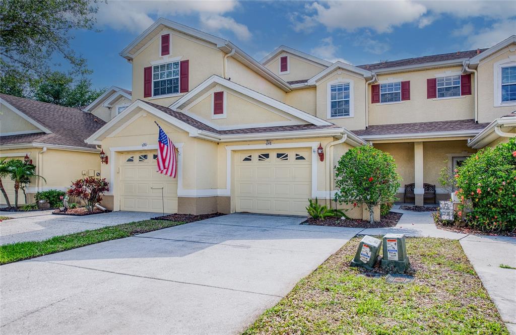 648 Spring Lake Circle Tarpon Springs, FL 34688 - Photo 29 of 30 a front view of a house with a yard and potted plants