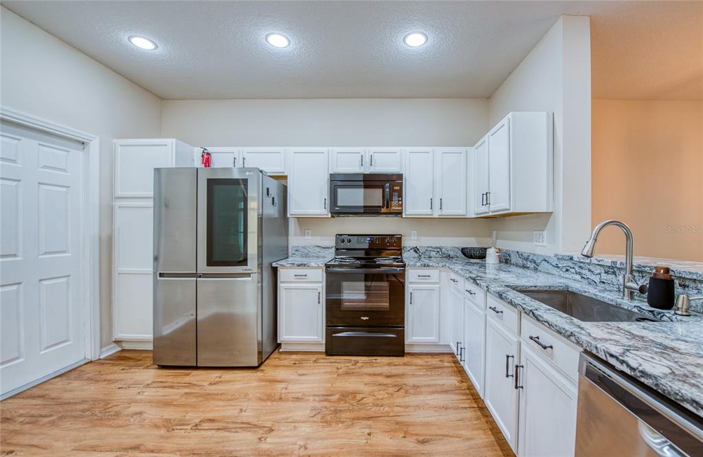 648 Spring Lake Circle Tarpon Springs, FL 34688 - Photo 6 of 30 a kitchen with stainless steel appliances granite countertop a refrigerator stove and sink