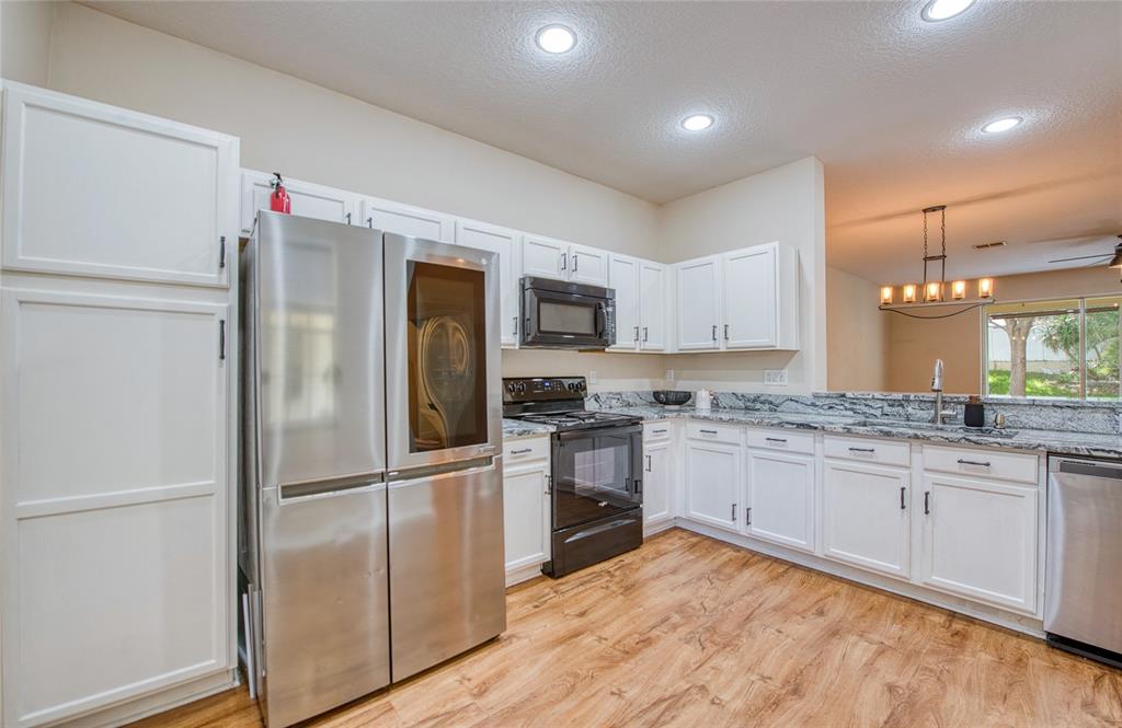648 Spring Lake Circle Tarpon Springs, FL 34688 - Photo 9 of 30 a kitchen with granite countertop a refrigerator and a sink